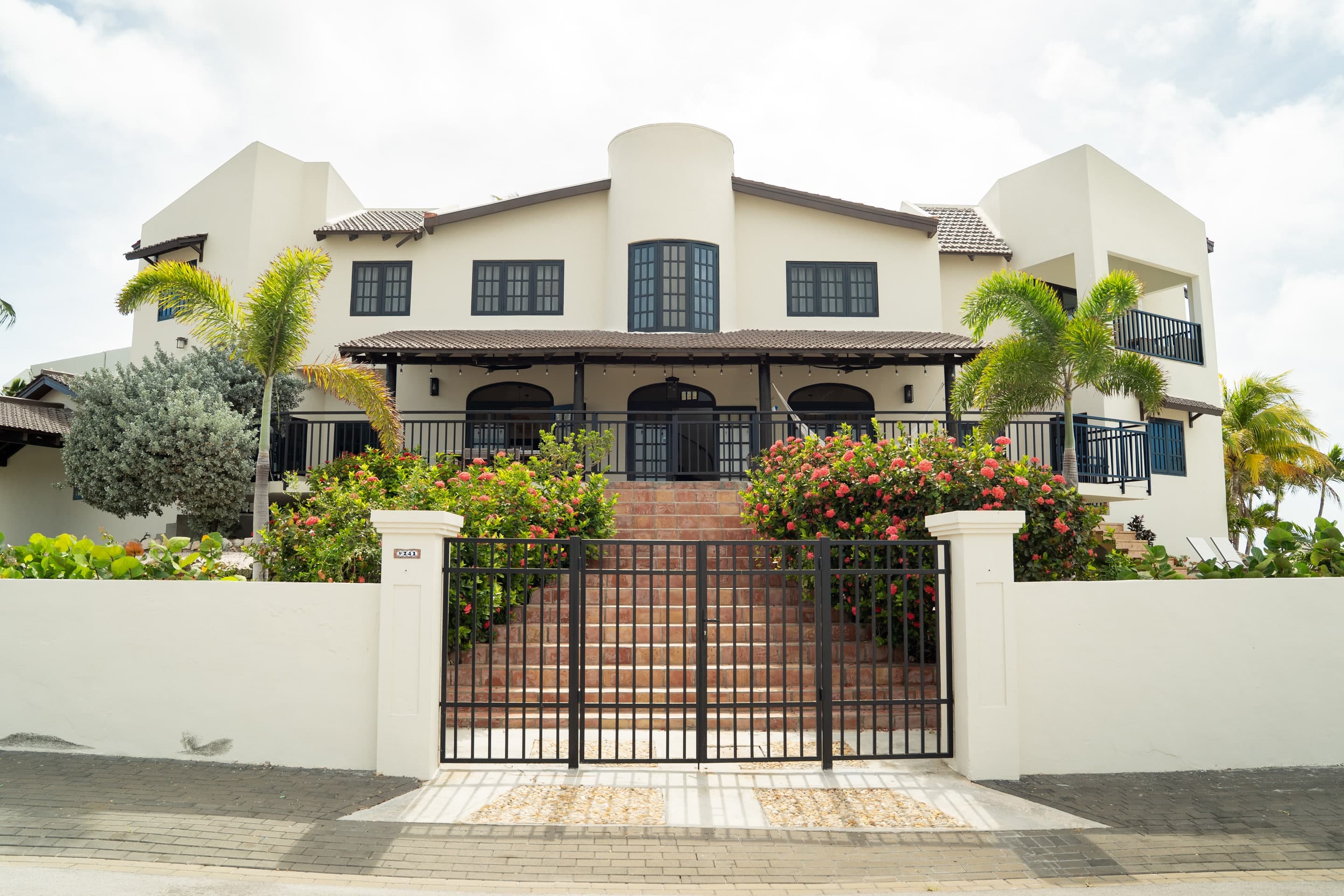 Exterior of The Villa Elizabeth in Jan Sofat, Curaçao, with tropical gardens and an iron gate